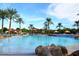 Large community pool and splash pad with palm trees, waterfalls, and shaded lounging areas at 20338 N 262Nd Ave, Buckeye, AZ 85396