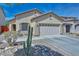 Charming single-story home featuring a two-car garage, desert landscaping, and a cozy front porch seating area at 20338 N 262Nd Ave, Buckeye, AZ 85396