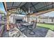 Cozy backyard gazebo featuring a fireplace, outdoor seating, decorative lighting, artificial grass and shade at 20338 N 262Nd Ave, Buckeye, AZ 85396