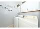 Bright laundry room featuring a modern washer and dryer, with ample cabinet space and stylish laundry-themed decor at 20338 N 262Nd Ave, Buckeye, AZ 85396