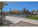 Resort-style pool and splash pad with shaded seating, surrounded by green lawns and mature trees at 20338 N 262Nd Ave, Buckeye, AZ 85396