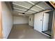 Empty one car garage with epoxy flooring and a side door at 225 N Pomeroy -- # 16, Mesa, AZ 85201