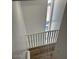 Well-lit stairway featuring white railings and wood-look flooring, leading up to a window at 225 N Pomeroy -- # 16, Mesa, AZ 85201