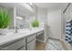Bright bathroom with a dual sink vanity, large mirror, and a glass-enclosed shower at 23932 W Hidalgo Ave, Buckeye, AZ 85326