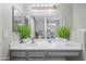 Bathroom featuring a dual sink vanity, a large mirror, and modern lighting fixtures at 23932 W Hidalgo Ave, Buckeye, AZ 85326
