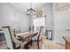 Dining room with a rustic wood table, upholstered chairs, modern light fixture and ceramic tile floors at 23932 W Hidalgo Ave, Buckeye, AZ 85326