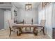 Bright dining room with a rustic wood table, upholstered chairs, chandelier, and ceramic tile floors at 23932 W Hidalgo Ave, Buckeye, AZ 85326