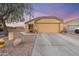 Inviting home exterior featuring a two-car garage and low maintenance desert landscaping at 23932 W Hidalgo Ave, Buckeye, AZ 85326