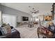 Open-concept living room boasts tile floors, a large TV, and seamless flow into the adjacent dining area at 23932 W Hidalgo Ave, Buckeye, AZ 85326