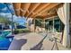 Inviting covered back patio with ceiling fan, lounge furniture, pool view and retractable sun shades at 24066 N 167Th Ln, Surprise, AZ 85387