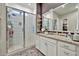 Bathroom with a modern walk-in shower, large vanity, and a walk-in closet at 24066 N 167Th Ln, Surprise, AZ 85387