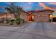 Spacious home with a three-car garage, desert landscaping, and a view of a colorful sunset at 24066 N 167Th Ln, Surprise, AZ 85387
