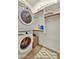 Efficient laundry room equipped with a stacked washer and dryer, and shelves for organization at 24066 N 167Th Ln, Surprise, AZ 85387