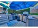Stainless steel outdoor kitchen with built-in BBQ grill, countertop and storage under a blue umbrella at 24066 N 167Th Ln, Surprise, AZ 85387