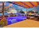 Stunning backyard featuring a sparkling pool, desert-themed mural, covered seating area, and lush landscaping at 24066 N 167Th Ln, Surprise, AZ 85387