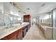 Large bathroom features a double sink, white countertops, and a soaking tub at 2850 N 152Nd Ln, Goodyear, AZ 85395