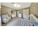 Light bedroom features a crib, rocker, white furniture, and a floral rug at 2850 N 152Nd Ln, Goodyear, AZ 85395