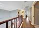 Upstairs hallway with wood railing and floors, leading to various rooms in the home at 2850 N 152Nd Ln, Goodyear, AZ 85395