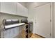A modern laundry room with side-by-side stainless steel washer and dryer and white cabinets at 2850 N 152Nd Ln, Goodyear, AZ 85395