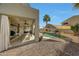 Covered patio with dining and living areas overlooks the pool and waterfall feature, perfect for outdoor relaxation at 2850 N 152Nd Ln, Goodyear, AZ 85395