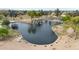 Scenic view of a pond featuring a waterfall, walking trails, and lush landscaping at 2850 N 152Nd Ln, Goodyear, AZ 85395