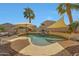 Inviting backyard pool with rock waterfall feature, surrounded by desert landscaping, lounge chairs, and shade umbrellas at 2850 N 152Nd Ln, Goodyear, AZ 85395