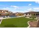 A private backyard with a pool, pergola, and lush green artificial turf creating a tranquil outdoor retreat at 31106 N 130Th Ln, Peoria, AZ 85383