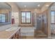 Bathroom featuring shower, tub, tile accents, and a large window at 31106 N 130Th Ln, Peoria, AZ 85383