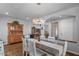 Elegant dining area featuring hardwood floors, a modern chandelier, and ample natural light at 31106 N 130Th Ln, Peoria, AZ 85383