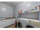 Bright laundry room featuring washer, dryer, cabinets and shelving at 31106 N 130Th Ln, Peoria, AZ 85383