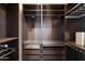 Closet with custom built-ins, shelving, drawers, hanging racks and a dark wood finish for optimal storage at 3302 N 7Th St # 211, Phoenix, AZ 85014