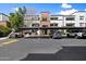 Modern apartment building with covered parking and manicured landscaping under a bright blue sky at 3302 N 7Th St # 211, Phoenix, AZ 85014