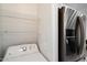 Efficient laundry area adjacent to a modern refrigerator, complete with shelving for storage solutions at 3302 N 7Th St # 211, Phoenix, AZ 85014