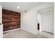 Modern living space with a distinctive brick accent wall, complemented by sleek flooring and lighting at 3302 N 7Th St # 211, Phoenix, AZ 85014