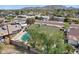 Aerial view of a backyard featuring a sparkling blue swimming pool surrounded by a concrete patio and mature trees at 3830 E Desert Cove Ave, Phoenix, AZ 85028