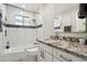 Modern bathroom featuring glass enclosed shower, white cabinets, and granite countertops at 3830 E Desert Cove Ave, Phoenix, AZ 85028