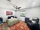 Well-lit bedroom featuring a ceiling fan, red accent rug, textured brick wall, and large window at 3830 E Desert Cove Ave, Phoenix, AZ 85028