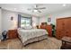 Comfortable bedroom featuring a ceiling fan, natural light, and classic wooden furniture at 3830 E Desert Cove Ave, Phoenix, AZ 85028