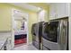 Laundry room with stainless steel washer and dryer, white cabinets, and view of the bedroom at 3830 E Desert Cove Ave, Phoenix, AZ 85028