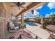 Inviting backyard with covered patio, swimming pool, lounge chairs, and lush landscaping at 43261 W Neely Dr, Maricopa, AZ 85138