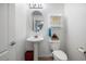 This bathroom features a pedestal sink, toilet, white fixtures, and decorative accents at 43261 W Neely Dr, Maricopa, AZ 85138