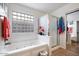 This ensuite bathroom features a soaking tub, glass block window, and a separate shower enclosure at 43261 W Neely Dr, Maricopa, AZ 85138