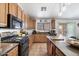 This eat-in kitchen features a spacious island, black appliances, wood cabinets, and access to the backyard at 43261 W Neely Dr, Maricopa, AZ 85138