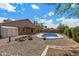 Backyard featuring a kidney-shaped pool with rock feature, a covered patio and ample space for outdoor relaxation at 450 E Duke Dr, Casa Grande, AZ 85122