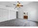 Comfortable bedroom with neutral carpet, white walls, a ceiling fan, and an en-suite bathroom at 450 E Duke Dr, Casa Grande, AZ 85122