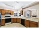 Traditional kitchen with wood cabinets, and an open view to the living area at 450 E Duke Dr, Casa Grande, AZ 85122