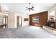 Open-concept living space with fireplace, neutral paint scheme, plush carpet, and view into the kitchen at 450 E Duke Dr, Casa Grande, AZ 85122