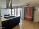 Kitchen island with cooktop and stainless vent hood with kitchen dining area and view to yard at 6207 W Orange Dr, Glendale, AZ 85301