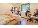 Cozy bedroom featuring tile flooring, a floral bedspread, and a window with an artistic covering at 7915 N 53Rd Dr, Glendale, AZ 85301