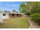 Lush backyard with a brick house, a covered patio, mature trees, and well-manicured lawn at 8629 E Cambridge Ave, Scottsdale, AZ 85257